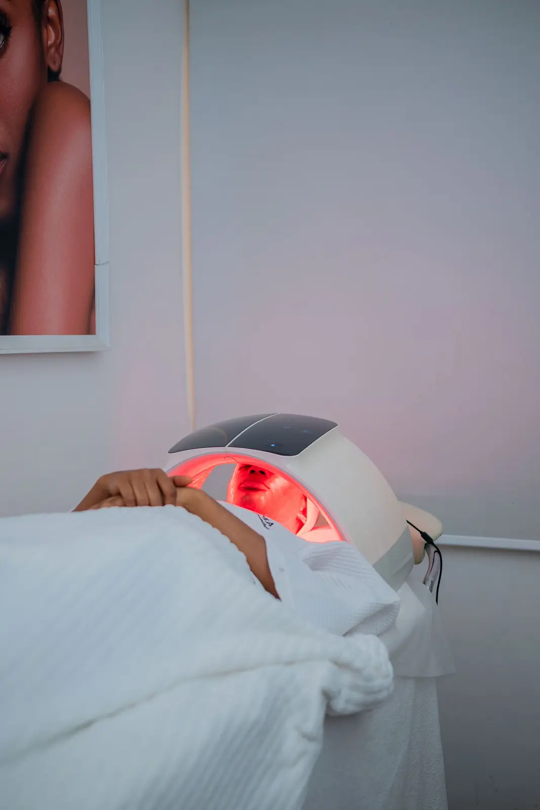 Cliente allongée recevant une séance de lumière LED rouge en institut