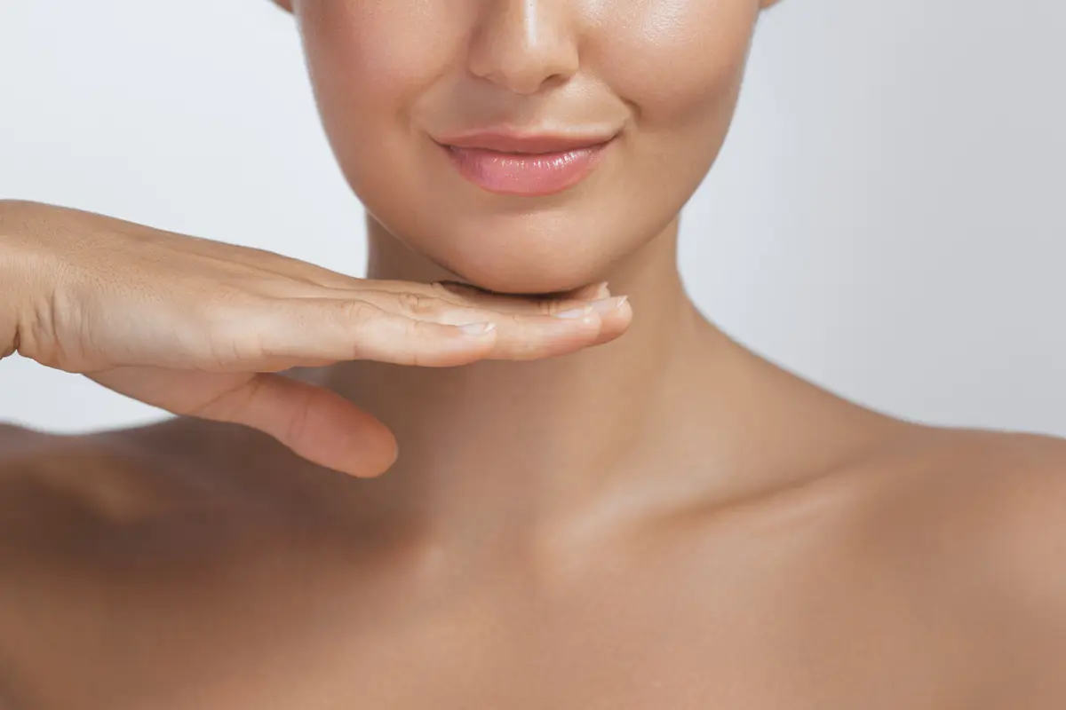 Main sous le menton, peau du visage et du cou