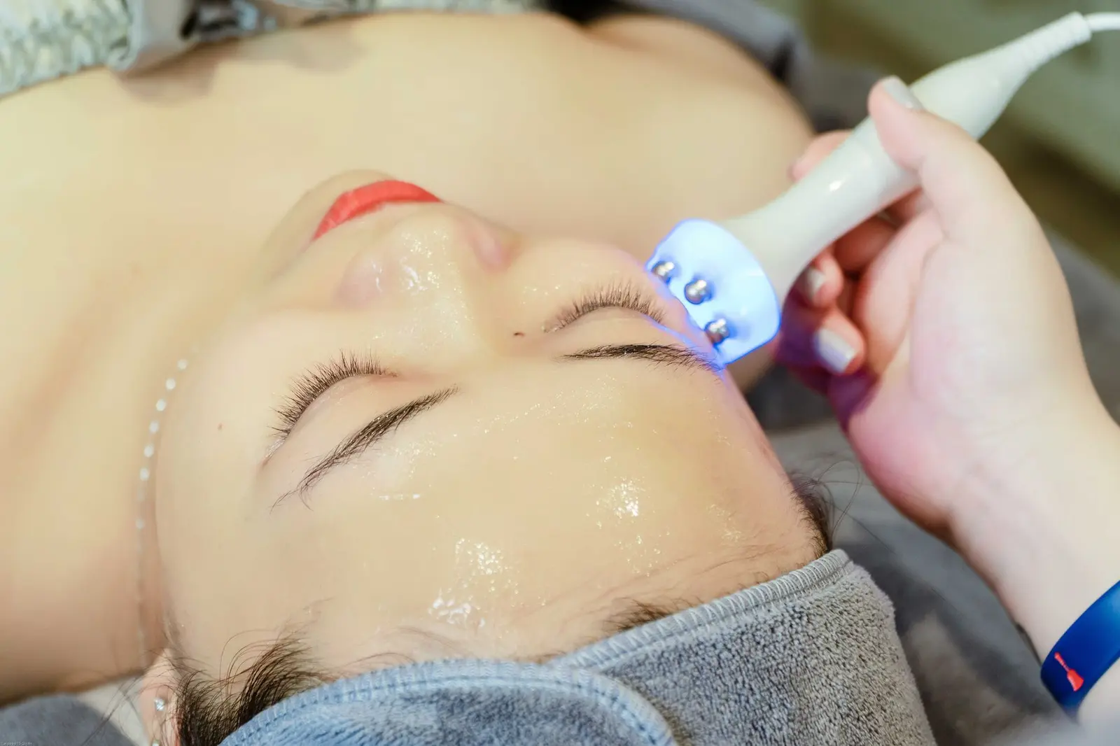Gros plan d'un soin du visage hydratant avec sonde sur une peau enduite de gel